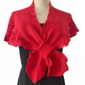 Close-up of a red knitted shawl featuring a delicate fish-tail hem and openwork texture. - Red