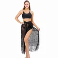 Close-up detail of black lace beach sarong with fringe worn by a model - One Size / Black