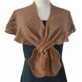 Close-up of a brown knit shawl capelet wrap with delicate fishtail edges on dress - Camel