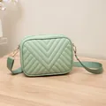 Stylish small mint green quilted camera bag with an adjustable fabric shoulder strap - Green