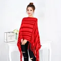 Elegante poncho de punto a rayas rojas con flecos llevado por una modelo en un estudio. - Tops / Rojo