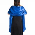 Back view of elegant royal blue satin shawl draped over a black formal evening gown - Sapphire Blue