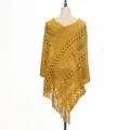 Detailed close-up of a yellow knitted hollow-out poncho with elegant long fringe hem - Tops / Yellow