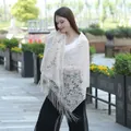Detailed macro view of champagne floral lace shawl with delicate tassels and embroidery - Beige