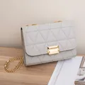 Elegant light grey chain crossbody bag with triangle quilted stitching and gold clasp - Gray