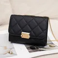 Elegant black quilted crossbody bag featuring a gold chain strap and lock closure - Black