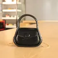 Sac à main en gelée noire brillante avec poignée intégrée et bandoulière chaîne dorée. - Noir