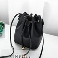 Minimalist black litchi grain leather drawstring bucket bag with gold metal beads. - Black