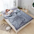Portable grey cotton travel sleeping bag liner with white triangle pattern on bed. - Gray White Triangle