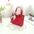 Elegant red fashion handbag with unique black crackle pattern and white silk scarf decoration - Red