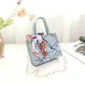 Elegant mint blue marble pattern handbag with decorative silk scarf and gold chain strap - Blue