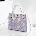Lavender floral print handbag featuring a white decorative bow and matching top handles - Daisy Print With Bow / Purple