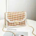 Elegant orange and white houndstooth crossbody bag featuring a gold-tone chain strap - White