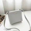 Elegant minimalist grey crossbody square bag showcased in a clean lifestyle setting - Light Gray