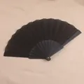 Vista detallada de un abanico plegable negro liso de 7 pulgadas con varillas de plástico duraderas - Negro
