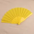 Gedetailleerde weergave van een gele plastic vouwwaaier van 7 inch op beige doek - Geel