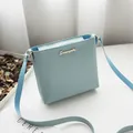 Minimalist light blue square shoulder bag with elegant gold script logo for modern women - Blue
