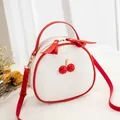 Stylish white cherry crossbody bag for women featuring red trim and lychee texture finish - White