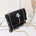 Elegant black patent leather square crossbody bag featuring gold tassel and chain strap - Black