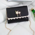 Chic black crossbody chain bag with pearl cat ornament and scalloped edge - Black (Leather)
