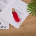 Macro view of an antique red feather ballpoint pen resting on an open magazine page - Gold Barrel / Red