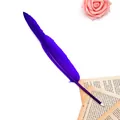 Detailed close-up of a vibrant purple feather ballpoint pen on vintage book paper - Blue