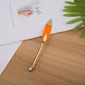 Elegante penna a sfera vintage con piuma arancione e fusto dorato su scrivania in legno - Arancione Con Stampa Oro