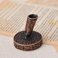Close-up of vintage bronze carved metal pen base on retro paper background - Antique Red Copper