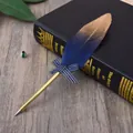 Close-up of elegant blue and gold feather ballpoint pen with decorative bow - Deep Blue Feather