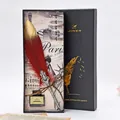 Gros plan d'un ensemble de plumes vintage dans un élégant coffret cadeau noir chic - Bordeaux