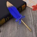 Detailed shot of a blue feather ballpoint pen with gold tip and bow on a book - Dark Blue Feather