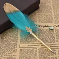 Close-up of turquoise feather ballpoint pen with gold leaf on vintage newspaper. - 青色(8064) / 0.5mm