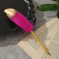 Primo piano di elegante penna a sfera in piuma rosa con punta dorata su pagina di libro - Rosso rosa