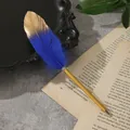 Dettaglio ravvicinato di un'elegante penna a sfera con piuma blu e oro su carta - Blu Zaffiro