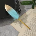Dettaglio di una penna a sfera creativa in piuma turchese e oro su un libro vintage. - Blu lago
