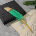 Primo piano di un'elegante penna a sfera con piume verdi e oro su un libro - Verde Cipresso