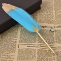 Elegante penna a sfera vintage con piuma blu e dettaglio decorativo a foglia d'oro - Celeste