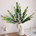 Close-up of artificial cactus plant inside creative fist-shaped white ceramic vase - Rose Red