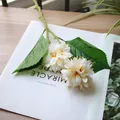 Close-up of white artificial ball chrysanthemum with natural green leaves - White and Orange