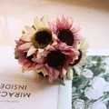 Close-up of pink and cream artificial sunflower bouquet on magazine background - Yellow Purple Sunflower