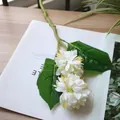 Detailed view of artificial white pompon mum flower with green leaves for home decor - White