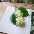 Detail shot of light green artificial chrysanthemums on a white magazine background - White Green