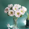 Detail view of light pink artificial gerbera daisies in a glass vase for home decor - Pink
