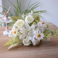 Detailed view of white artificial bouquet with dahlia, roses, and daisies on wood - White