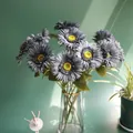 Detailed view of artificial gray African daisies in a elegant gold-rimmed glass vase - Blue