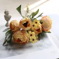 Nahaufnahme eines gelben Seiden-Ranunkel-Bouquets mit Gänseblümchen für die Deko - Orange