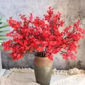 Detalle de ramas de gypsophila roja artificial en jarrón vintage sobre mantel de encaje - Rojo