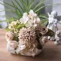 Nahaufnahme eines herbstlichen Kunstblumenstraußes mit Rosen und Hortensien in einer Vase - Welkes Blatt
