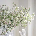 Primer plano de flores de paniculata artificiales rosa y blancas en un jarrón de cristal - Rosa