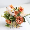 Nahaufnahme eines gemischten künstlichen Blumenstraußes aus Pfingstrosen und Rosen - Orange